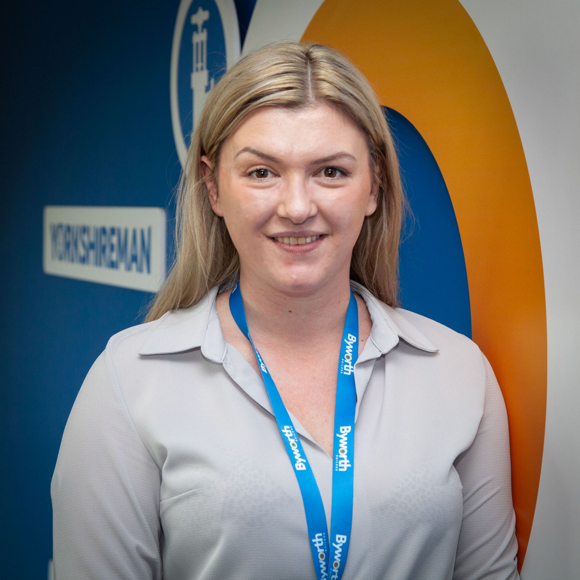 Woman stood in front of a blue and orange wall facing camera